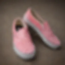 A pair of pink Vans slip-ons with checkerboard patterns showcased on a skateboard.