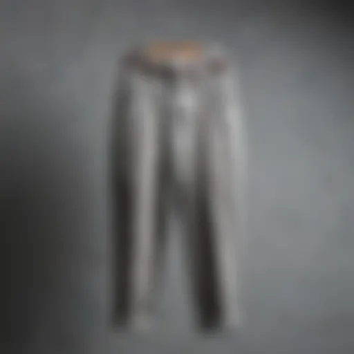 Elegantly draped grey cord pants on a hanger