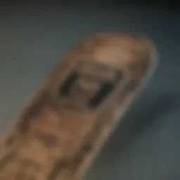 A close-up of a skateboard deck featuring Crooks and Castles graphics