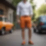 Orange chino shorts styled with a classic white button-up shirt and loafers